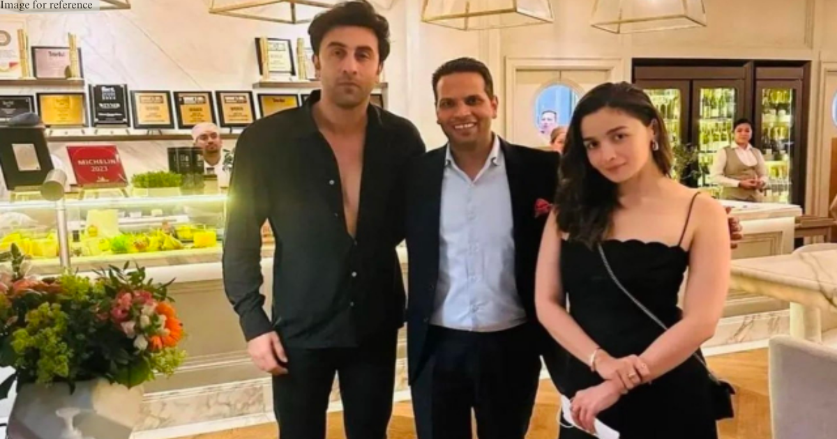 Alia Bhatt and Ranbir Kapoor pose for a photo with a fan, while wearing matching black outfits for a date night in Dubai